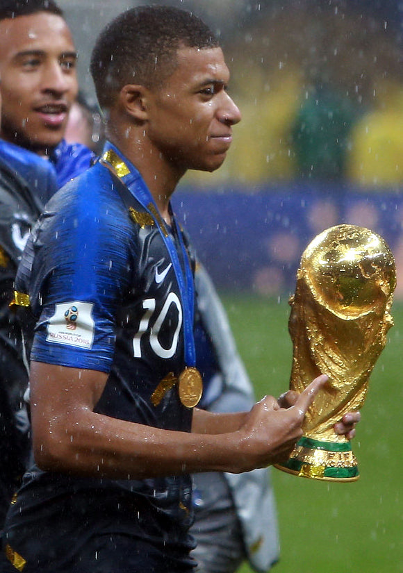 Kylian Mbappe holding the FIFA World Cup trophy